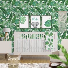 a baby's room decorated in green and white with palm leaves on the wall