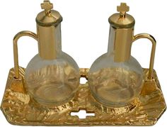 two glass vases sitting on top of a metal tray with gold foiled handles