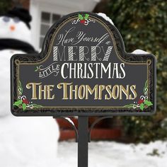 a snowman is standing next to a christmas sign