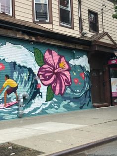 a mural painted on the side of a building in front of a fire hydrant