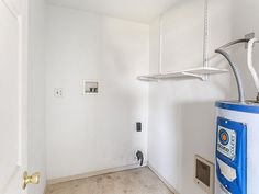 a white room with a water heater in the corner and a blue tank next to it