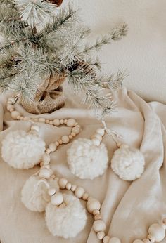 a white christmas tree with pom - poms on it