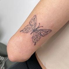 a woman's arm with a butterfly tattoo on the left side of her body