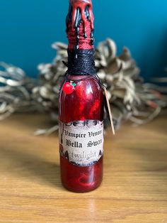 a red bottle sitting on top of a wooden table