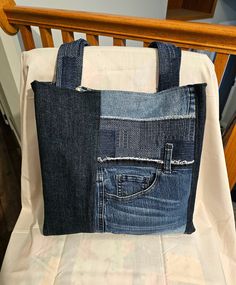 a bag made out of jeans sitting on top of a bed