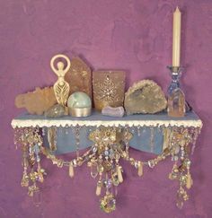 a table topped with lots of items next to a purple wall