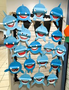 a bunch of blue sharks hanging from the side of a door with their mouths open