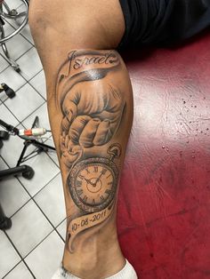 a man with a tattoo on his leg holding a clock