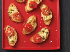 toasted bread with tomatoes and cheese on a red plate