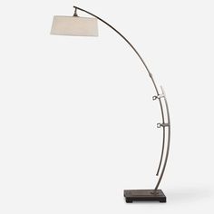 a floor lamp with a white shade on it's side and a black base