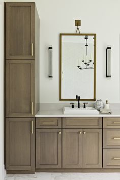 a bathroom with two sinks, cabinets and a large mirror on the wall above it