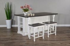 a kitchen island with two stools and a potted plant