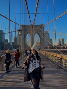 a woman walking across a bridge in new york city