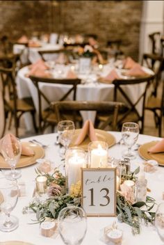 the table is set with candles, plates and napkins for guests to sit at