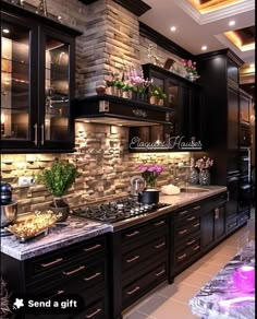 a kitchen with black cabinets and stone backsplash