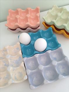 three egg trays sitting on top of a table next to an egg in the middle