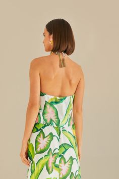 Embrace the tropical vibe with the Summer Foliage Off White Croped Top by FARM Rio. This halter neckline top features a vibrant leafy pattern, evoking the lush landscapes of Brazil. The delicate ruffles and eyelet fabric add a touch of femininity to the piece, while the cropped silhouette keeps it modern and fresh. Perfect for a summer day out, this top will bring a playful and stylish flair to your wardrobe. Composition 55% LINEN 45% VISCOSE Care Instructions MACHINE WASH GENTLE CYCLE, DO NOT B Vacation Floral Print Halter Neck Top, Tropical Halter Top For Vacation, Green Tropical Halter Top For Summer, Summer Tropical Print Triangle Halter Top, Tropical Green Halter Top For Summer, Spring Tropical Triangle Halter Top, Sleeveless Tropical Print Halter Top For Spring, Tropical Halter Neck Top For Poolside, Spring Vacation Tropical Print Halter Top