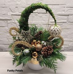 a basket filled with pine cones, ornaments and greenery next to a brick wall