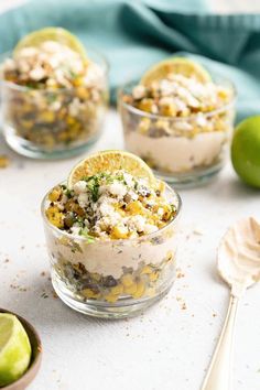 three small glass bowls filled with food on top of a white table next to limes