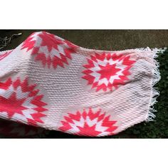 a red and white blanket laying on the ground