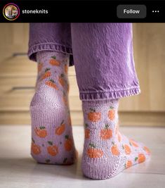 the legs and ankles of a person wearing socks with pumpkins on them, standing in a kitchen