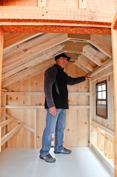 a man standing inside of a wooden building