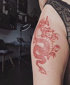 a woman with a dragon tattoo on her thigh