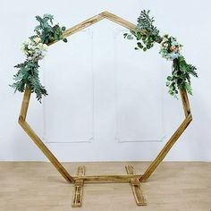 a wooden frame decorated with flowers and greenery