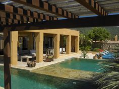 an outdoor swimming pool with lounge chairs and umbrellas