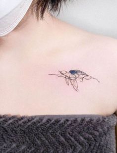 a woman's shoulder with a small tattoo on it