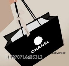 a person holding a black shopping bag with the word chanel printed on it, in front of a beige background