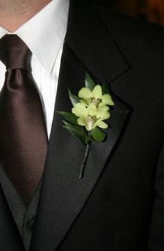 a man wearing a suit and tie with flowers on it's lapel flower