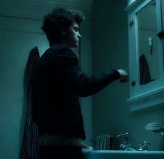 a man standing in front of a bathroom sink