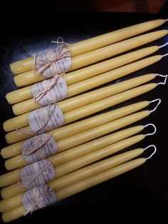 several yellow candles with tags tied to them