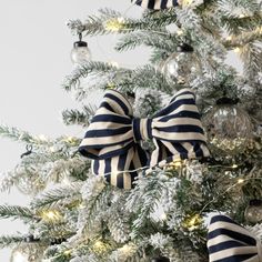 a decorated christmas tree with blue and white striped bows on it's bowes