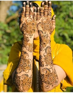 a woman with her hands covered in hendi on the side of her face and arms