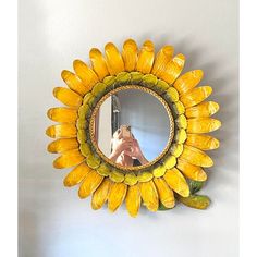 a yellow sunflower shaped mirror hanging on the wall