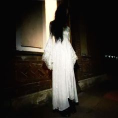 a woman standing in front of a window at night