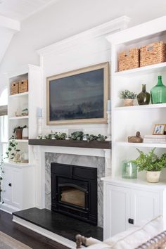 a living room with a fireplace and white shelves