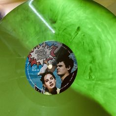 a green vinyl record with an image of two people on it