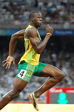 a man running on a track in front of a crowd