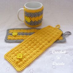 a crocheted yellow and gray scarf next to a coffee mug