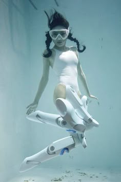 a woman in white swimsuit floating underwater