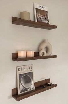 two wooden shelves with candles and pictures on them