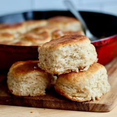 three biscuits stacked on top of each other in front of a skillet