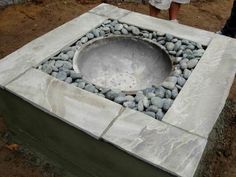 a concrete fire pit with rocks around it