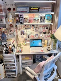 a white desk topped with a laptop computer next to a chair and shelves filled with books