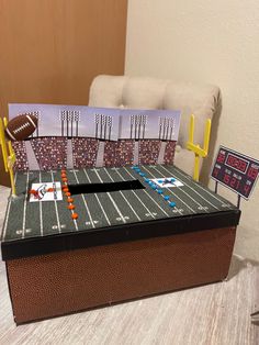 a football themed table with a card board and game in the box on it, next to a chair