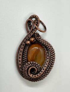 Two Tone Orange Agate Pendant in layers of wire wrapped copper with copper accent beads. Approximately 1 13/16" long and just over an 1" wide. Based on a Nicole Hanna Design. This pendant has been antiqued, polished and sealed. Sealed with Protectaclear. ProtectaClear is a clear, protective coating that is tough enough to protect jewelry and is safe for wear against skin. ProtectaClear is practically invisible once applied and will seal and protect jewelry from tarnish, oxidation, and corrosion. Orange Agate, Copper Accents, Copper Pendants, Agate Pendant, Wire Wrapping, Two Tone, Agate, Copper, Orange