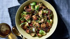 a bowl filled with brussel sprouts next to a cup of coffee